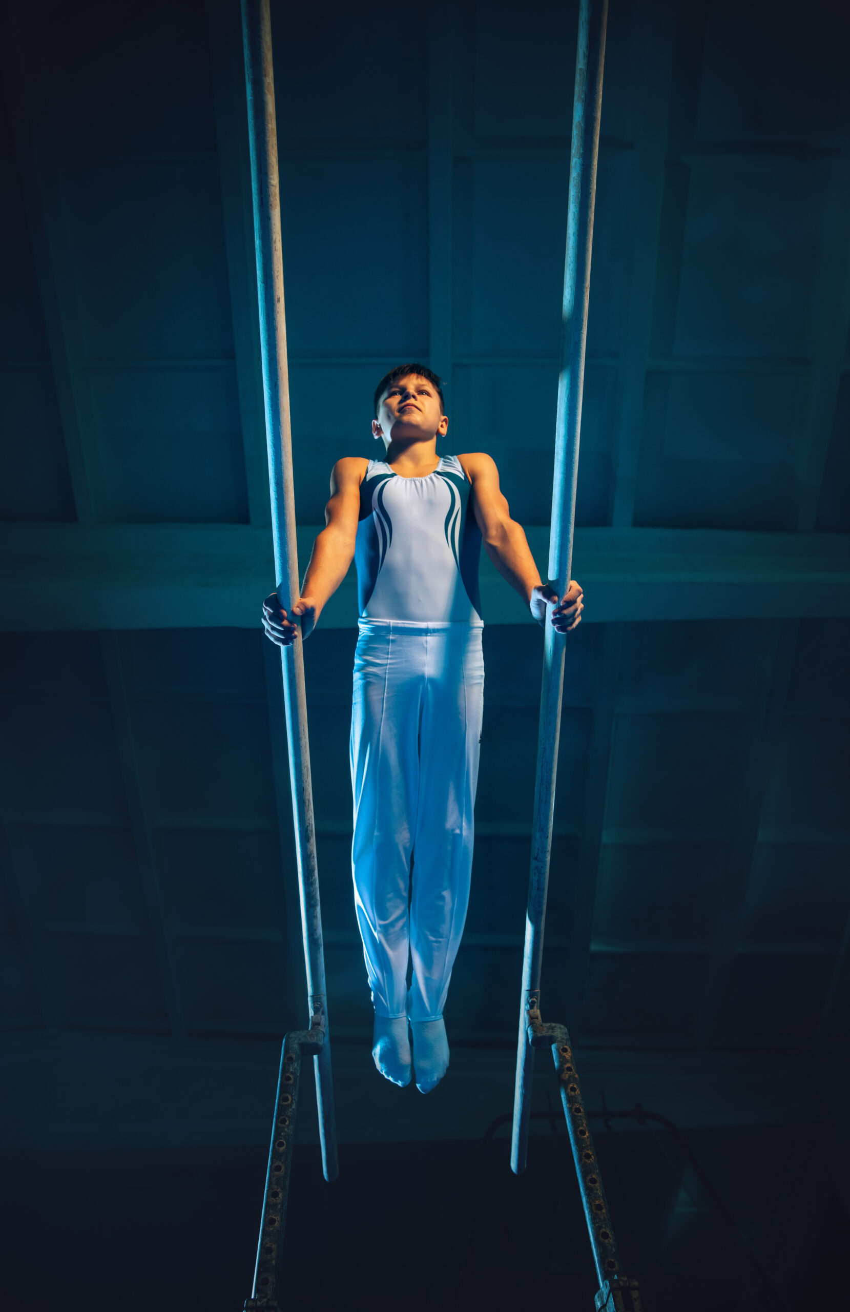 Little male gymnast training in gym, flexible and active